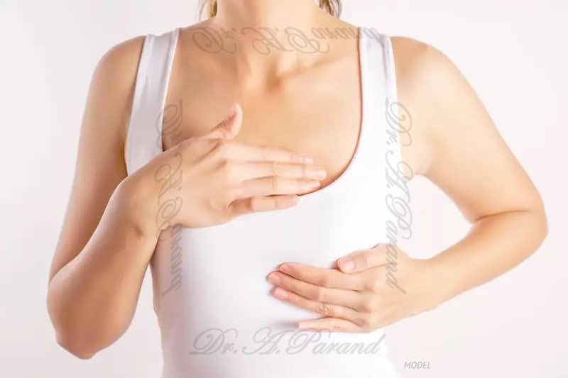 woman massaging her breast مراقبت های بعد از جراحی ماموپلاستی | دستورات الزامی پزشکی